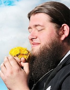 man smelling flower